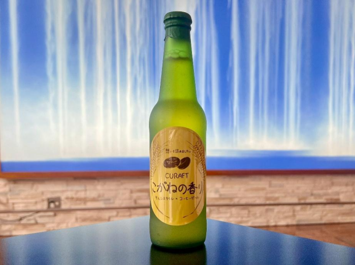 こがねの香りのパッケージ。瓶は黄緑色で、その外側に手書きの商品名が書かれている。